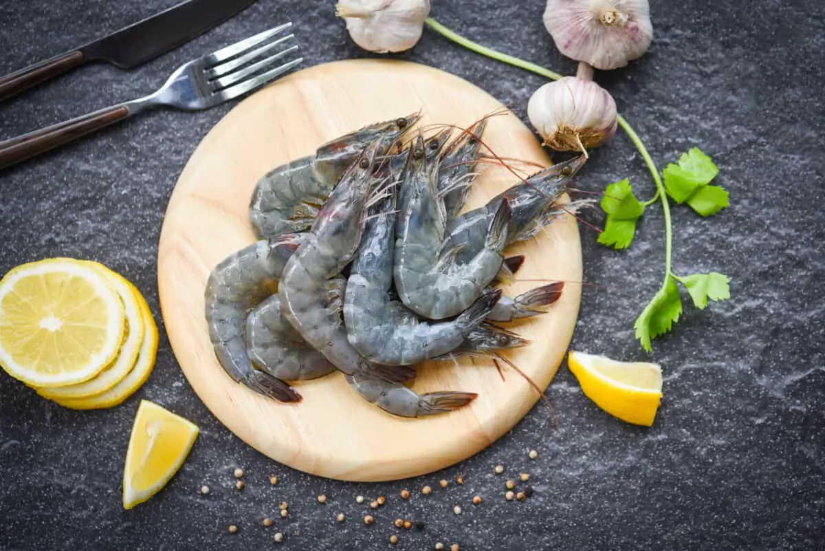 raw shrimps on wooden cutting board plate